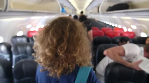 Interior of Airplane with Passengers Looking for Seats Stock Footage 58582403