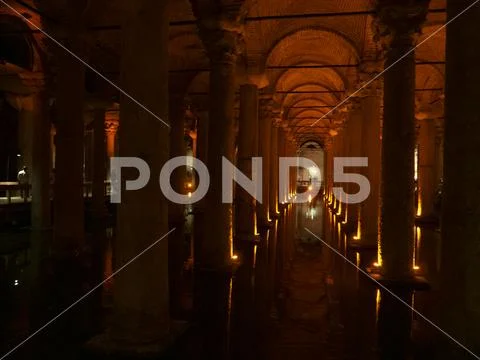 Interior of Basilica Cistern illuminated with orange colored lights. Stock Photos