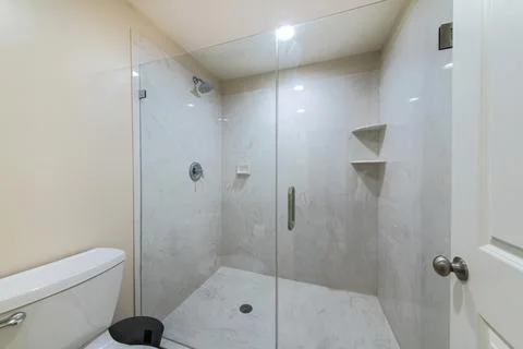 Interior of a bathroom with frameless shower stall Stock Photos