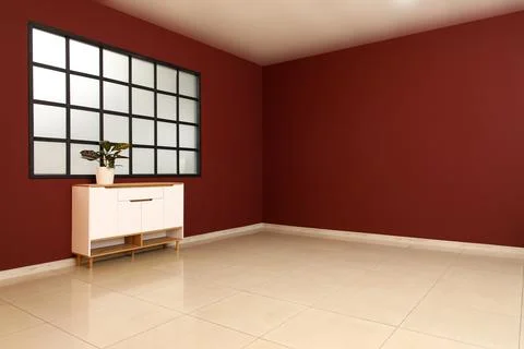 Interior of big empty room with window and houseplant on commode near burgund Stock Photos
