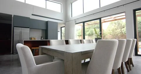 Interior of bright open plan dining room and kitchen with doors to garden, copy Stock Photos