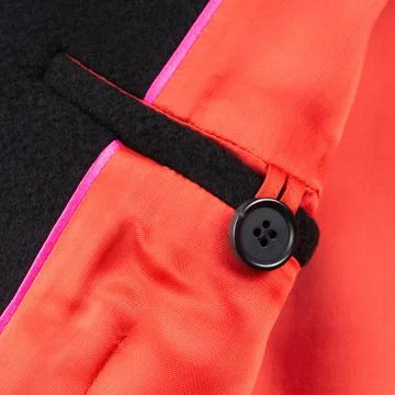 Interior button pocket in black wool coat with bright red lining. Close up Foto stock