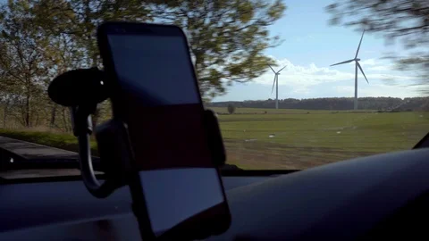 The interior of the car with a view of the mobile phone and windmills. Stockbeeldmateriaal 97540707