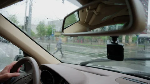 Interior car view through a rain covered windshield during wet weather Stock Footage 336907806