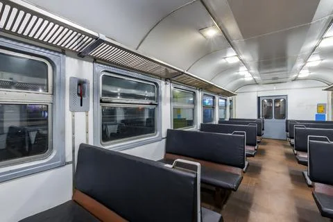 Interior of an cheap empty train car with simple bench-style seating. The car Stock Photos