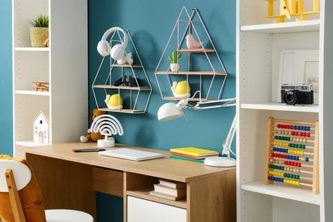 Interior of children's room with study table, shelf units and toys Stock Photos