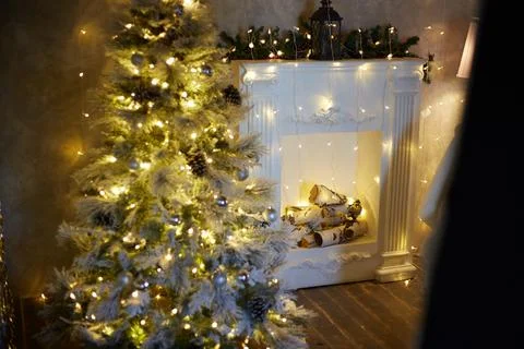 Interior christmas. magic glowing tree, fireplace gifts in dark at night Stock Photos