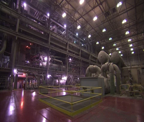 Interior coal power plant. Worker in hard hat checks gauges; does inspection. Stock Footage 86694442