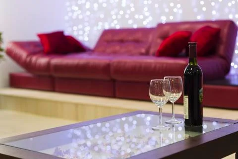 Interior with a coffee table, a sofa and a bottle of wine Stock Photos