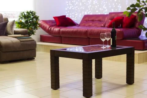 Interior with a coffee table, a sofa and a bottle of wine Stock Photos