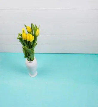 Interior composition of a home, white ceramic vase with fresh flowers on blue Stock Photos