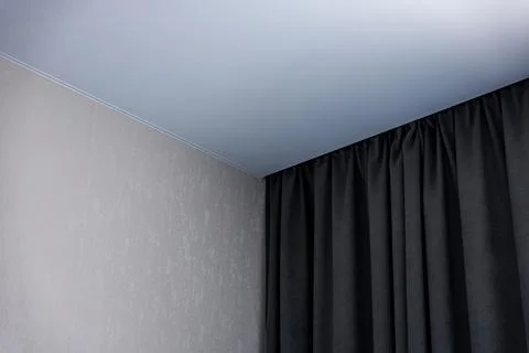 Interior corner with light gray wall, black curtains, and blue ceiling, Minsk Stock-Fotos