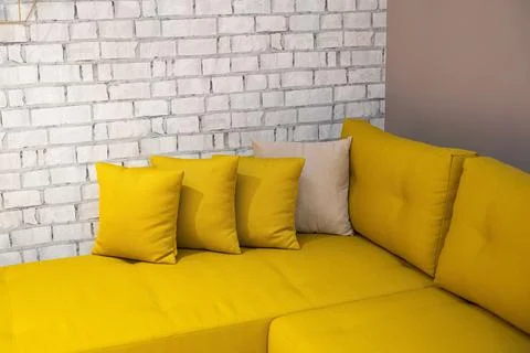 Interior of a corner yellow sofa with pillows Stock Photos