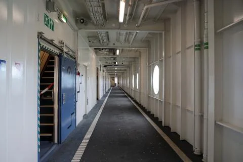 Interior corridor of a ferry showcasing clean lines, circular windows, and .. Stock Photos