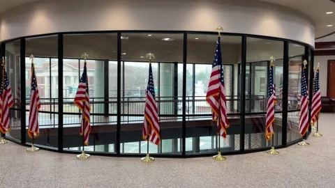 Interior County Courthouse Flags by a row windows and traffic outside Stock Footage 148967278