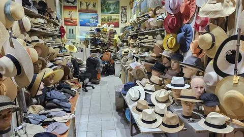 Interior of a crowded hat shop filled with a lot of straw hats, fedoras, and Stock Photos