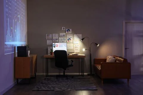 Interior of dark data scientist's office with workplace, projector screen and Stock Photos