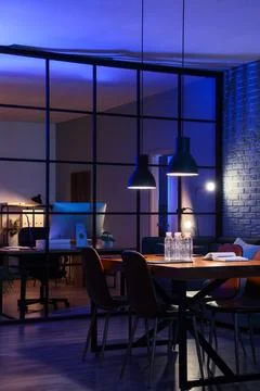 Interior of dark office with table, folding screen and glowing lamps at night Stock Photos