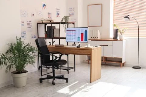 Interior of data scientist's office with workplace, shelf unit and diagrams Stock Photos