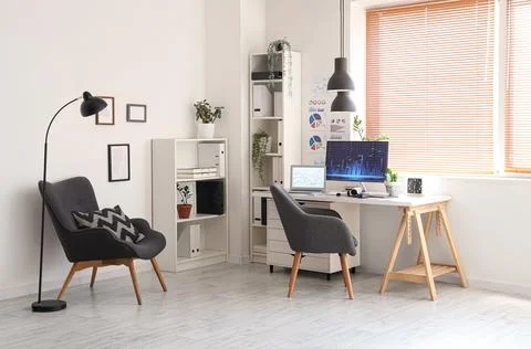 Interior of data scientist's office with workplace, shelf units and armchair Stock Photos