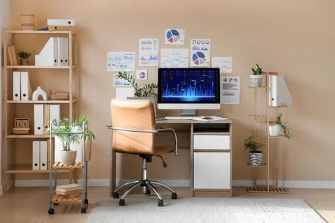 Interior of data scientist's office with workplace, diagrams and shelf unit Foto stock
