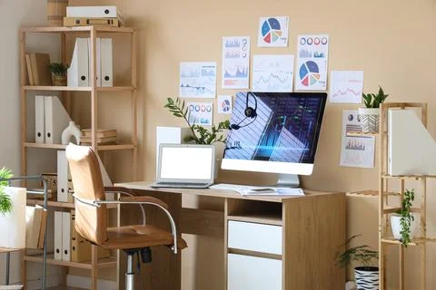 Interior of data scientist's office with workplace, diagrams and shelf unit Stock Photos