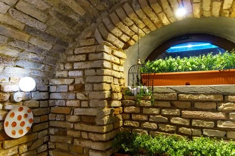 Interior design in a cafe in the loft style. Rough walls of old red brick and Foto stock