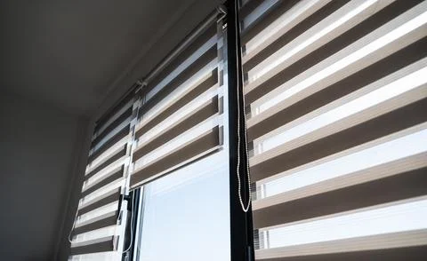 Interior design with double zebra blinds filtering daylight through glass window 스톡 사진
