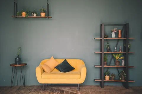 Interior design room or studio. Furniture against a green wall and wooden flo Stock Photos