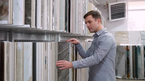 Interior designer choosing flooring tile color texture samples at hardware store Stock Footage 262501162