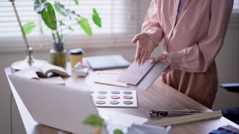 Interior designer comparing wood and material samples while reviewing furni.. Video stock 336916236