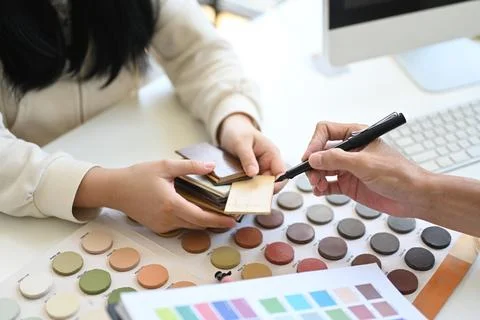 Interior designer giving advice to client, selecting design elements for new Foto stock