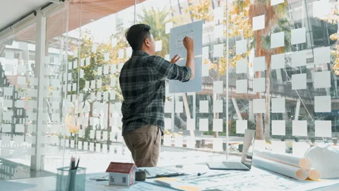 Interior designer or architect reviewing blueprints and holding pencil drawin Stock Footage 165194862