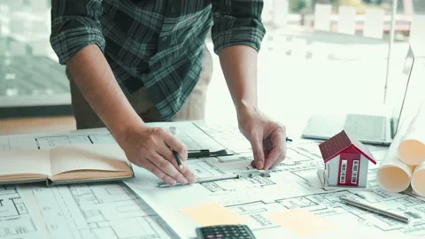 Interior designer or architect reviewing blueprints and holding pencil drawin Stock Footage 167246836