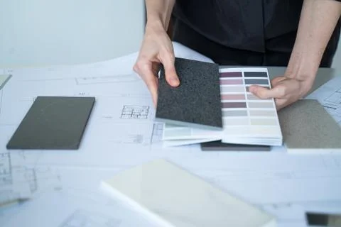 The interior designer selects ceramic stoneware and marble samples. Designer at Stock Photos