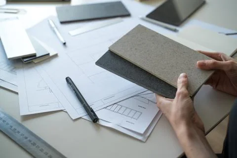 The interior designer selects ceramic stoneware and marble samples. Designer at Stock Photos