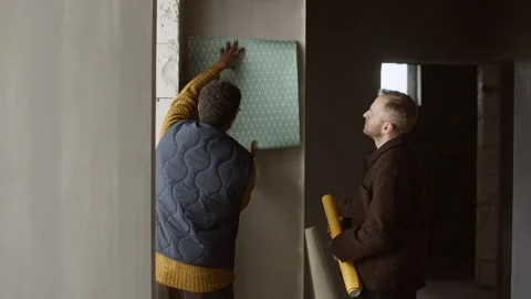 Interior Designer Showing Wallpaper Sample to Client at Renovation Site Stock Footage 320674898