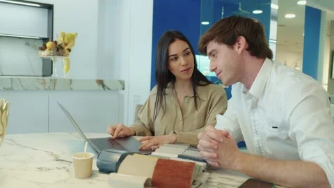 Interior designers discussing renovation project with laptop and material Stock Footage 311390341