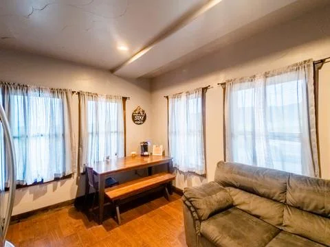 Interior of dining area with small bench table and grey couch sitting area. Foto stock