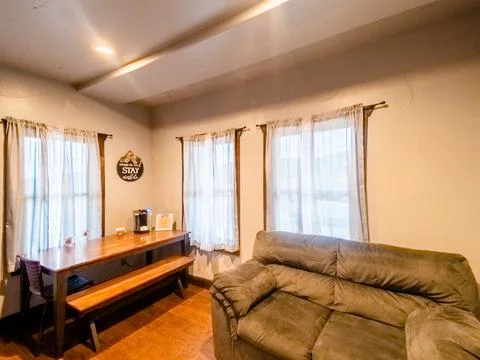 Interior of dining area with small bench table and grey couch sitting area. Stock Photos