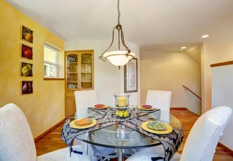 Interior of dining room with yellow contrast wall and hardwood floor. Stock Photos