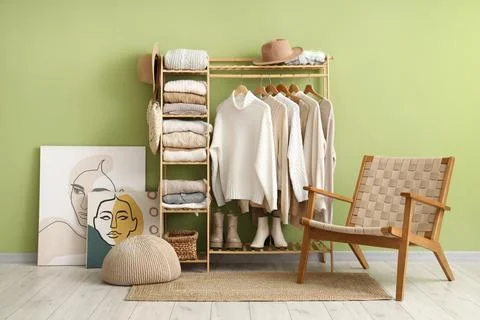 Interior of dressing room with warm sweaters and armchair Stock Photos