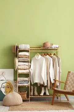Interior of dressing room with warm sweaters and armchair Stock Photos