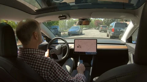 Interior of a driver using Autopark feature to parallel park in a Tesla. Stock Footage 113389191
