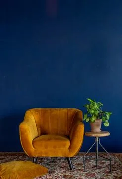 Interior element, yellow empty armchair against blue wall background, copy space Stock Photos