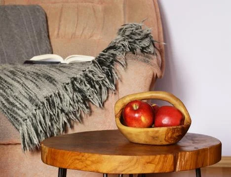 Interior elements - chair, blanket, coffee table and red apples Stock Photos