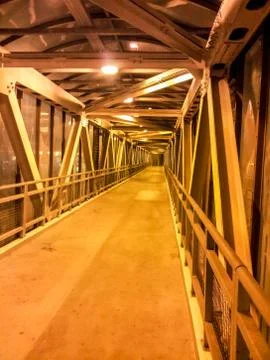 Interior of an elevated pedestrian crosswalk at night. Yellow lighting Stock Photos