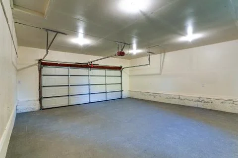 Interior of an empty clean garage with closed door in a house. Stock Photos