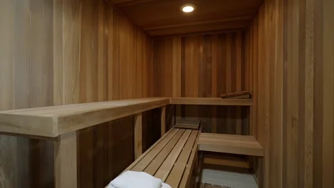 Interior of empty finnish sauna with classic wooden design and turned on halogen Stock Footage 265201618