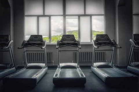 Interior of an empty gym with view of the picturesque mountains. Treadmill. 库存照片